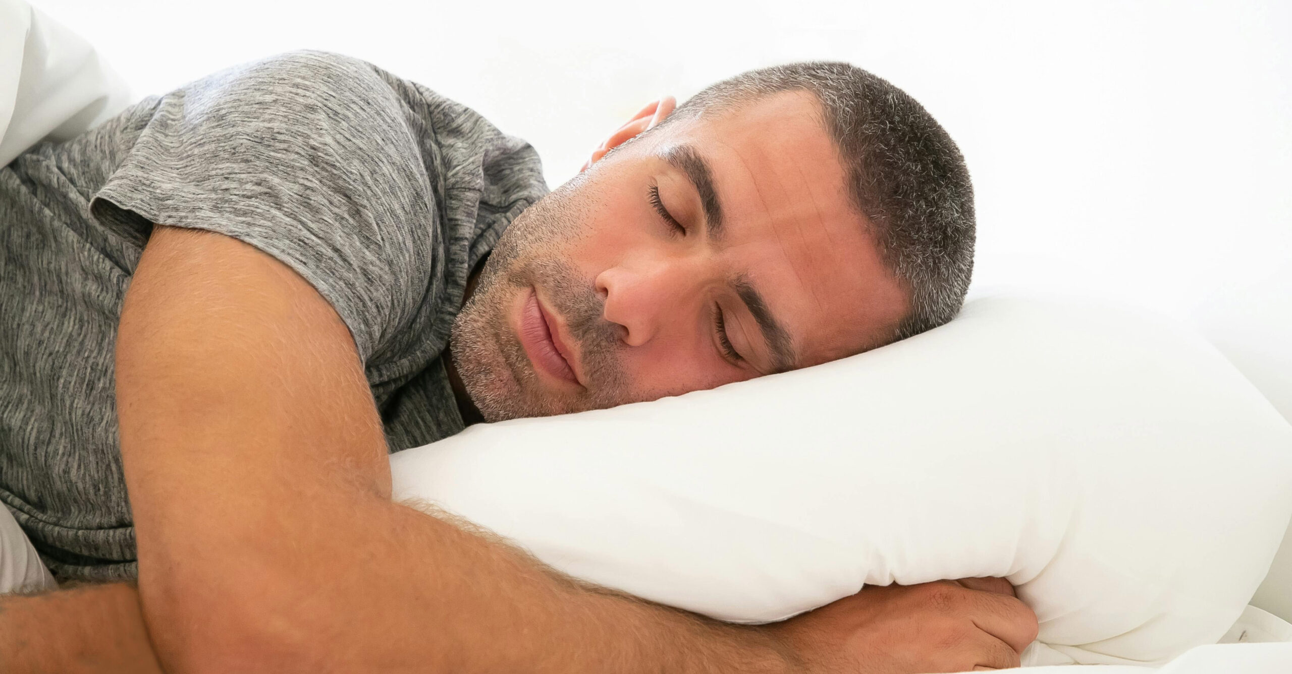 Image of a man sleeping peacefully with his head resting on a pillow