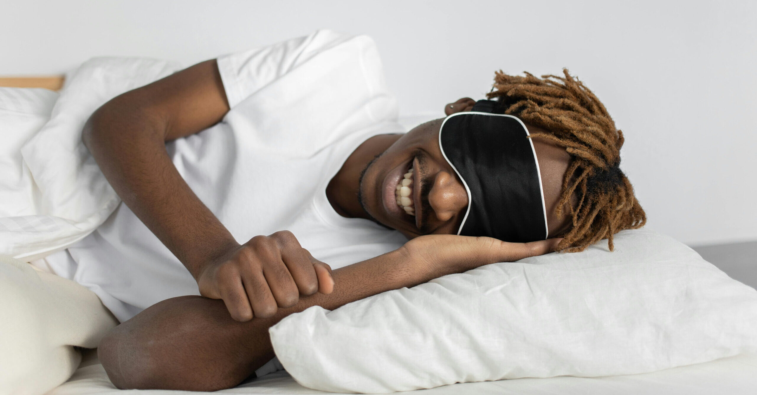 Man wearing sleeping mask and resting his head on a pillow